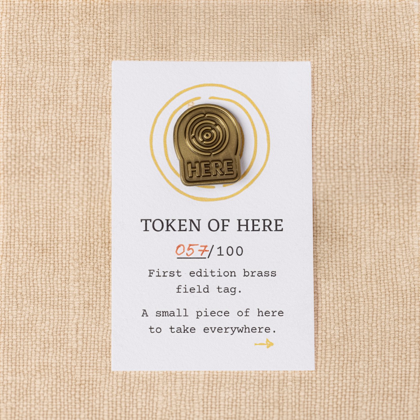 First-edition brass field tag from the Kit of Here with numbered backing card, made to carry as a daily reminder of place.