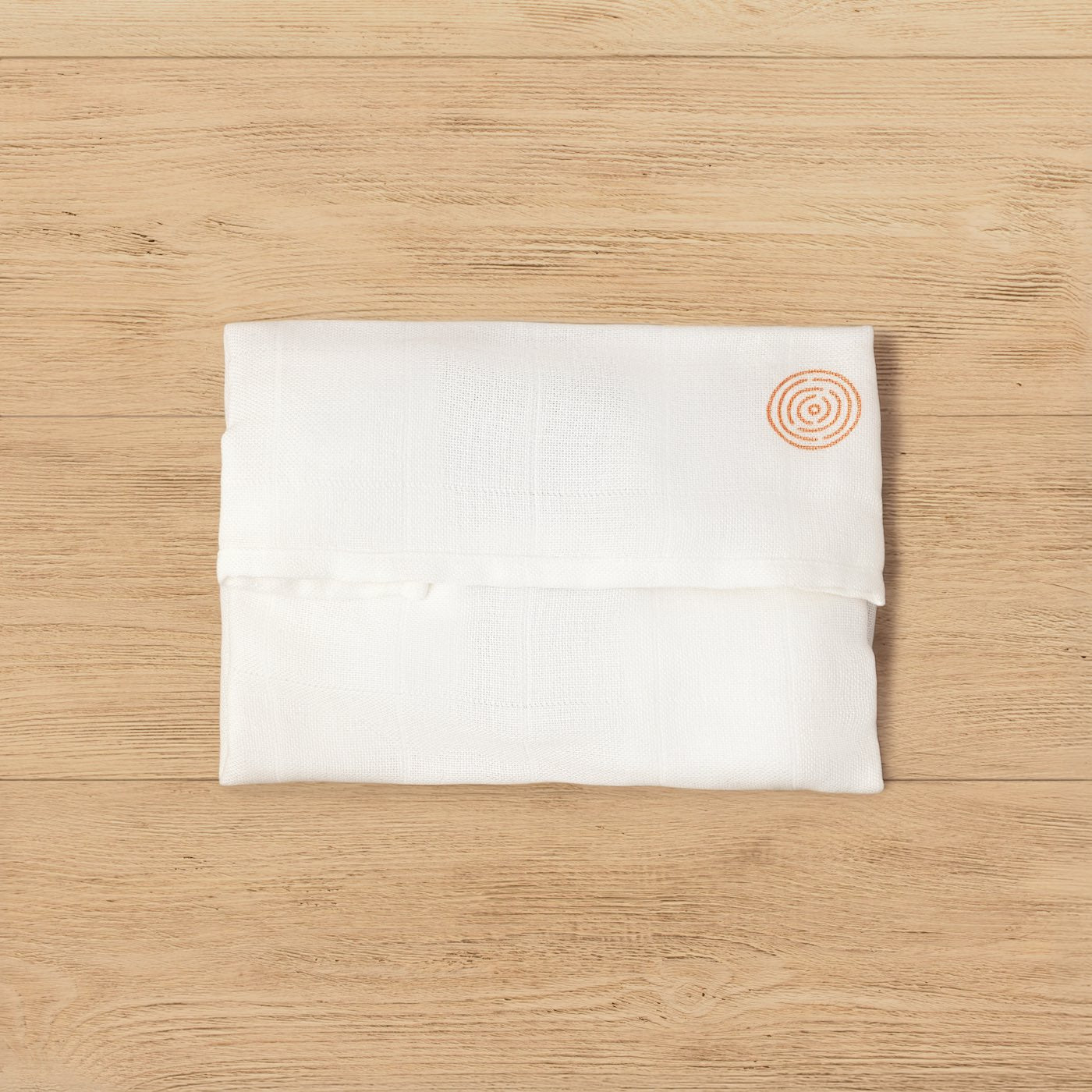 Handmade muslin-wrapped Kit of Here sealed with a wax stamp, presented on a wooden surface.